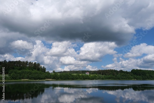 Amazing scenery of kashubian landscape with Grabowko lake and clouds on blue sky in summer day. Kashubia, Pomerania, Poland