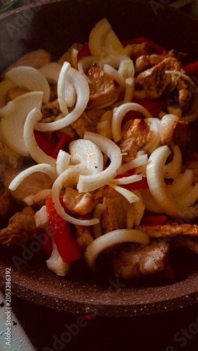 Fried Meat Pieces with Onions and Red Peppers in a Pan – Cooking Dinner Close-up