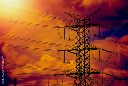 High-Voltage Power Pylon during Dramatic Golden Orange Sunset