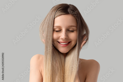 Cuadro en lienzo Happy young woman with long blonde hair and closed eyes, hair care and beauty co