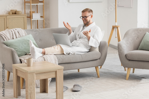 Relaxed man in robe on sofa...
