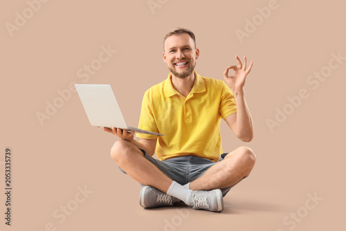 Smiling young man with lapt...