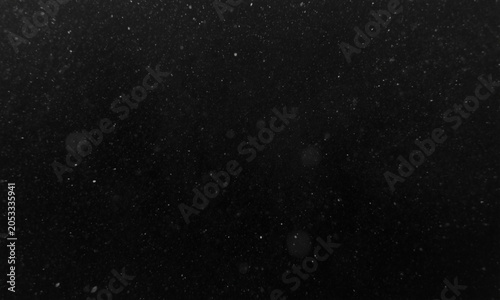 Floating dust particles in darkness with soft bokeh highlights