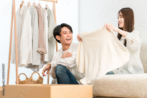 Cuadro en lienzo A young Asian couple, married, tidying up their clothes and changing their wardrobe in their living room