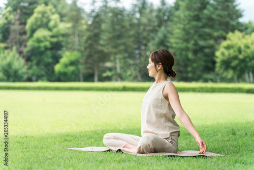 Foto Asian women taking deep breaths, stretching, and doing yoga in a park