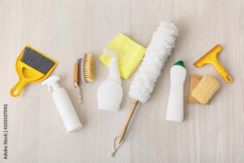 Fototapeta premium Home cleaning supplies and tools for housekeeping, top view of various household products on wooden floor