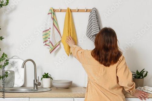 Woman hanging yellow kitche...