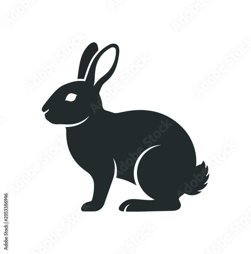 Silhouette of a black rabbit sitting attentively.