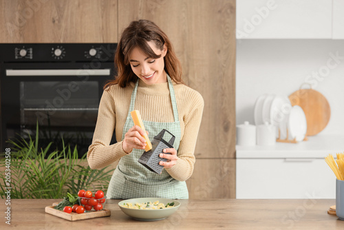 Smiling woman grating chees...