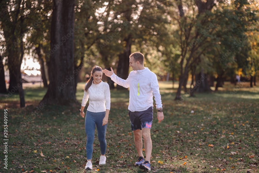 Fototapeta premium Couple enjoying autumn walk discussing active lifestyle