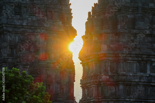 Bild auf Leinwand Sunlight pierces ancient stone towers Prambanan temple