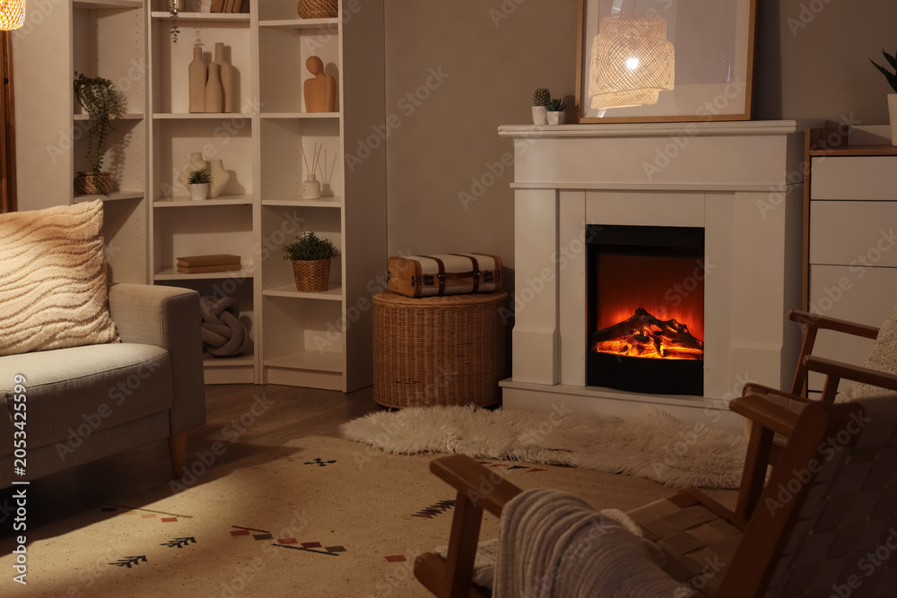 Obraz premium Cozy living room interior with electric fireplace, comfortable sofa, and decorative bookshelves for home comfort