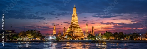 Wat Arun Temple at Dusk: A breathtaking panoramic view of the majestic Wat Arun temple in Bangkok, illuminated against the vibrant hues of the twilight sky.