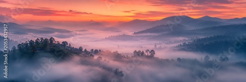 Misty Mountain Sunrise: A breathtaking sunrise paints the sky in vibrant hues of orange and pink, casting a magical glow over rolling mountains shrouded in ethereal mist.