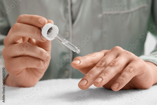Woman applying skincare ser...