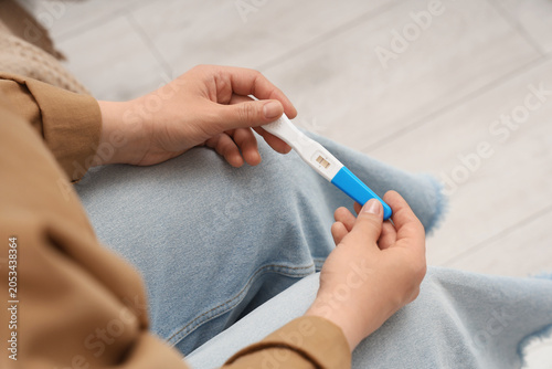 Принти на полотні Woman's hands holding a positive pregnancy test, family planning and fertility c