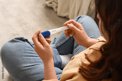 Fotografie Woman holding pregnancy test, anticipating results, family planning, reproductiv