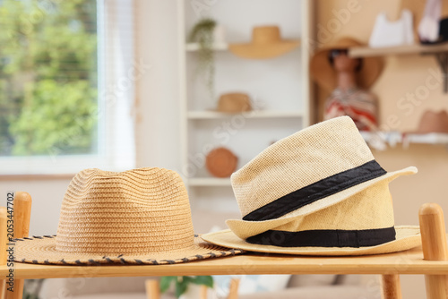 Obraz na plátně Straw hats displayed on wooden shelf in bright retail store, fashion accessories