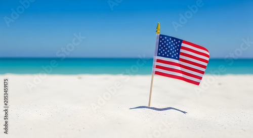 American flag waving on sandy beach with clear blue ocean and sky in patriotic celebration