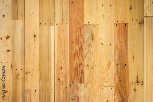 Natural Light Wood Plank Wall Background. Rustic timber texture featuring vertical wooden planks with natural warm grain patterns, knots, and visible nail heads, creates an organic backdrop.