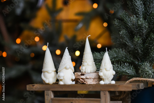 Unique handmade soy wax candles, cozy room with wooden decorations and Christmas lights in the background