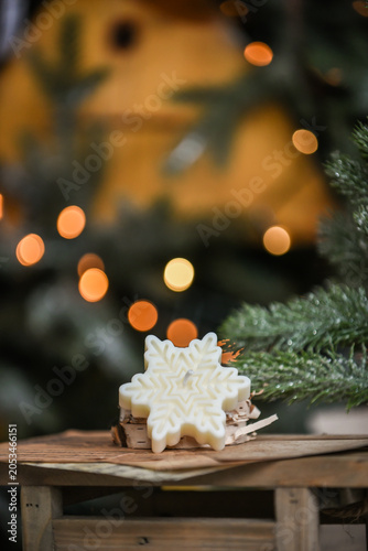 Unique handmade soy wax candles, cozy room with wooden decorations and Christmas lights in the background