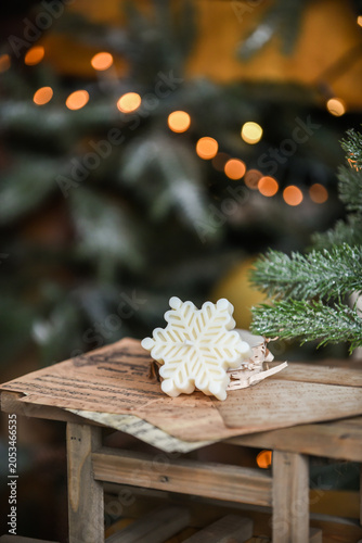 Unique handmade soy wax candles, cozy room with wooden decorations and Christmas lights in the background