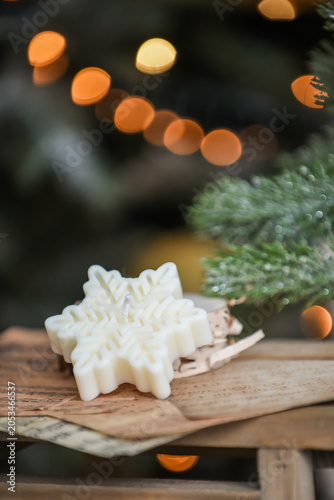 Unique handmade soy wax candles, cozy room with wooden decorations and Christmas lights in the background