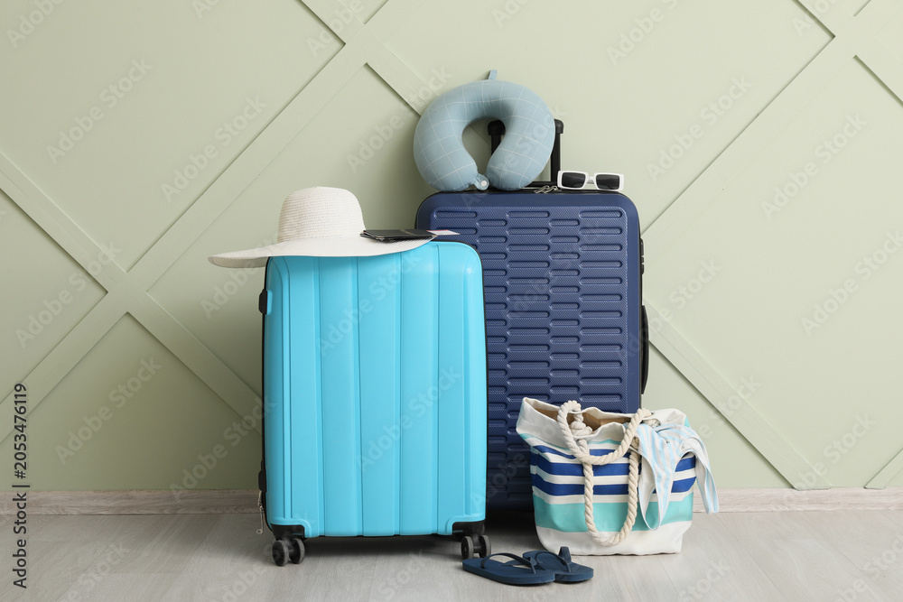 Fototapeta premium Travel preparation with blue and cyan suitcases, beach bag, and vacation accessories for summer getaway