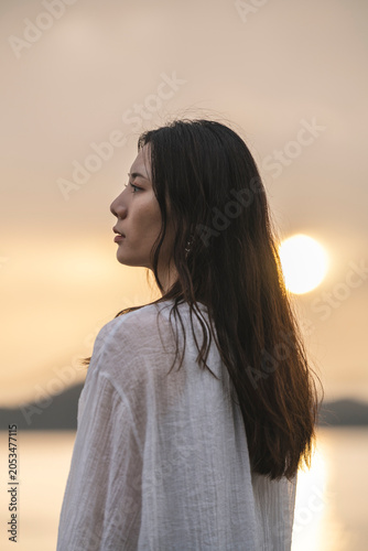 夕暮れの海にいる女性