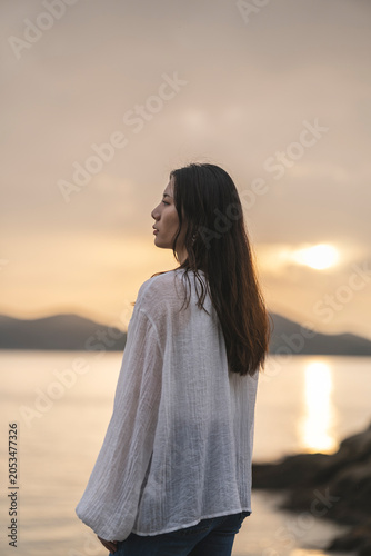 夕暮れの海にいる女性