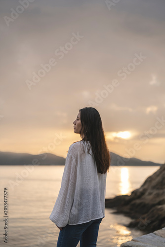 夕暮れの海にいる女性