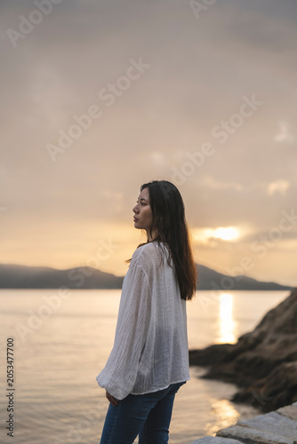 夕暮れの海にいる女性
