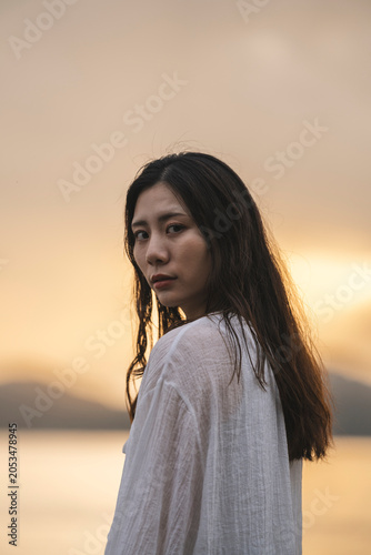 夕暮れの海にいる女性