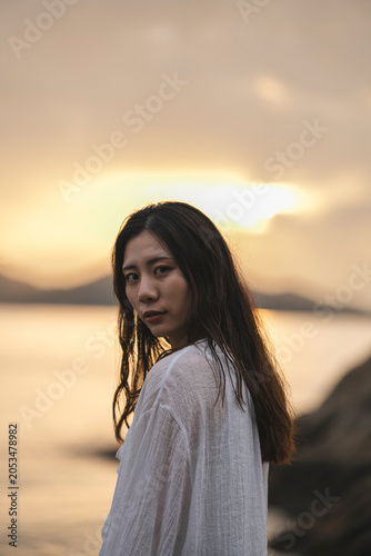 夕暮れの海にいる女性