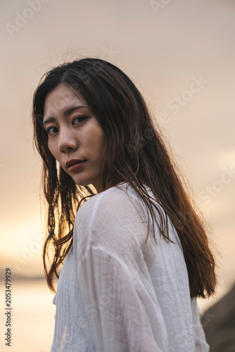 夕暮れの海にいる女性