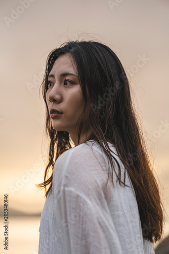 夕暮れの海にいる女性