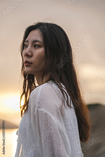 夕暮れの海にいる女性