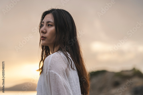 夕暮れの海にいる女性