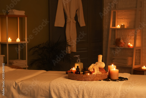 Photography Relaxing spa treatment room with massage table, warm candlelight, and wellness p