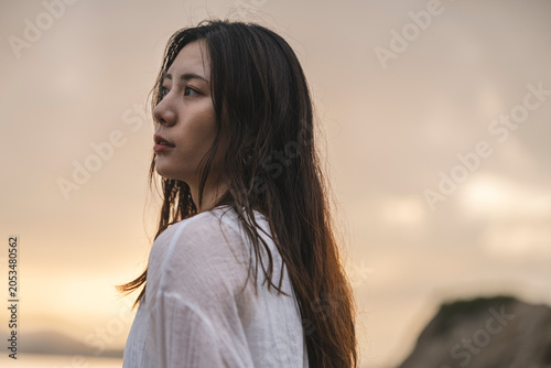 夕暮れの海にいる女性