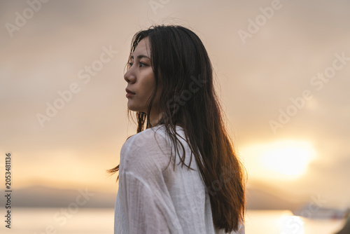 夕暮れの海にいる女性