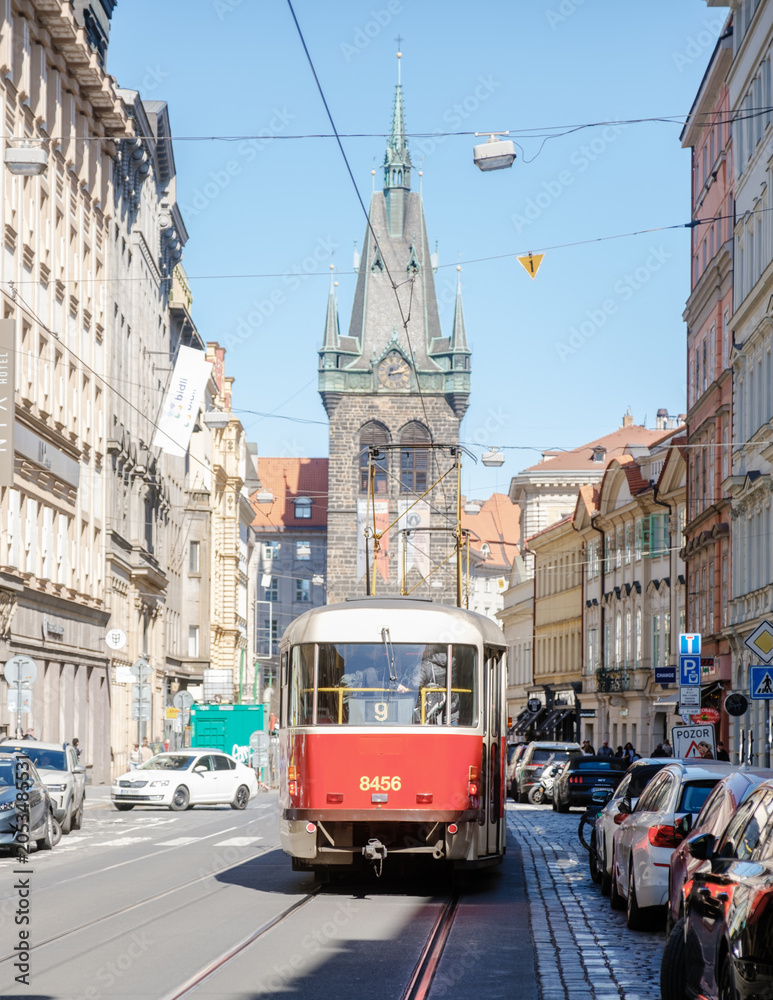 Fototapeta premium Explore the charm of Prague on a sunny April day with tram 9 passing historic architecture