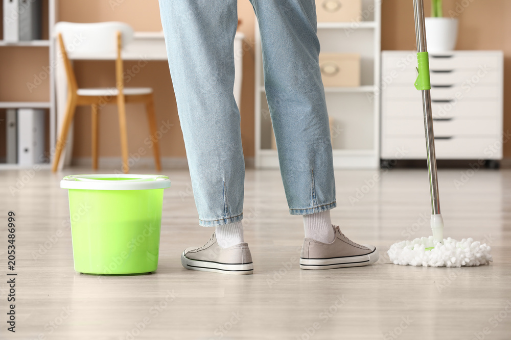 Fototapeta premium Person cleaning home floor with mop and bucket, housekeeping and domestic chores, residential maintenance and hygiene