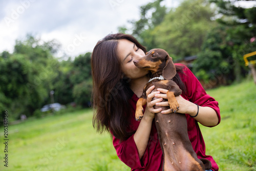 Foto Woman dog kiss pet dachshund outdoor grass park affection companion, woman kissi
