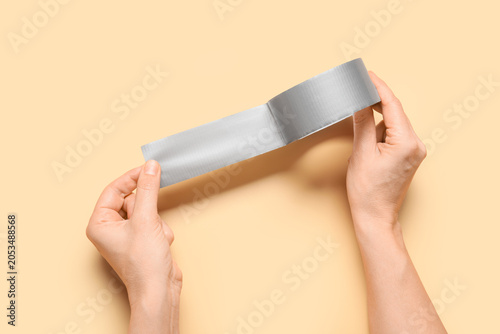 Hands holding gray duct tap...