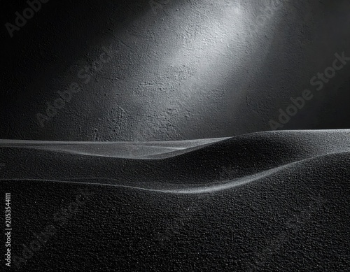 Black and white image features abstract landscape with rolling hills, lit by an overhead spotlight