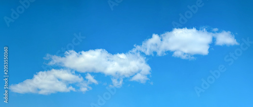 фотографія A small long clouds moves across the clear blue sky