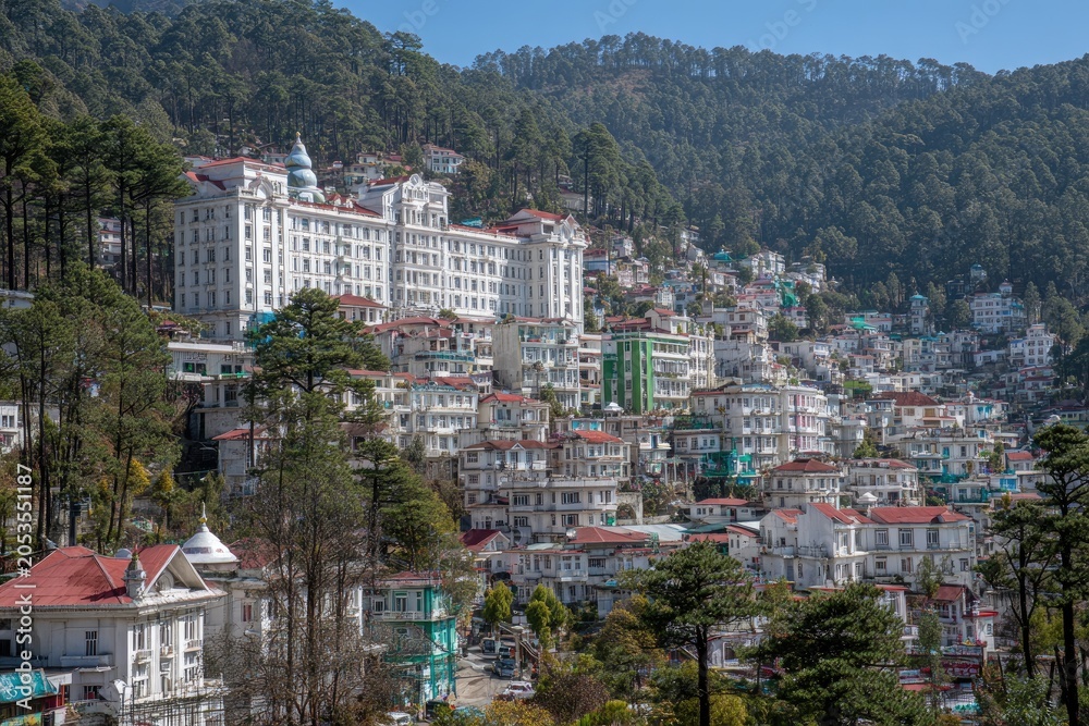 Fototapeta premium Majestic white building overlooks a hillside town with colorful structures