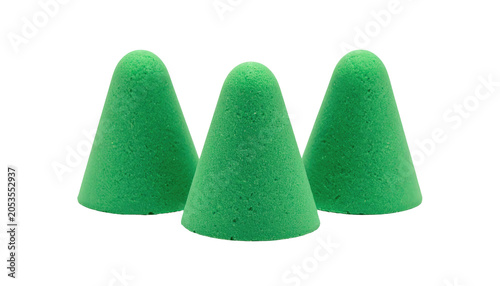 Three bright green, conical shapes, resembling miniature trees, sit against a black background, with soft, textured surfaces